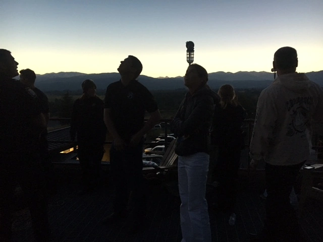 Menschen beobachten eine totale Sonnenfinsternis bei Sonnenuntergang