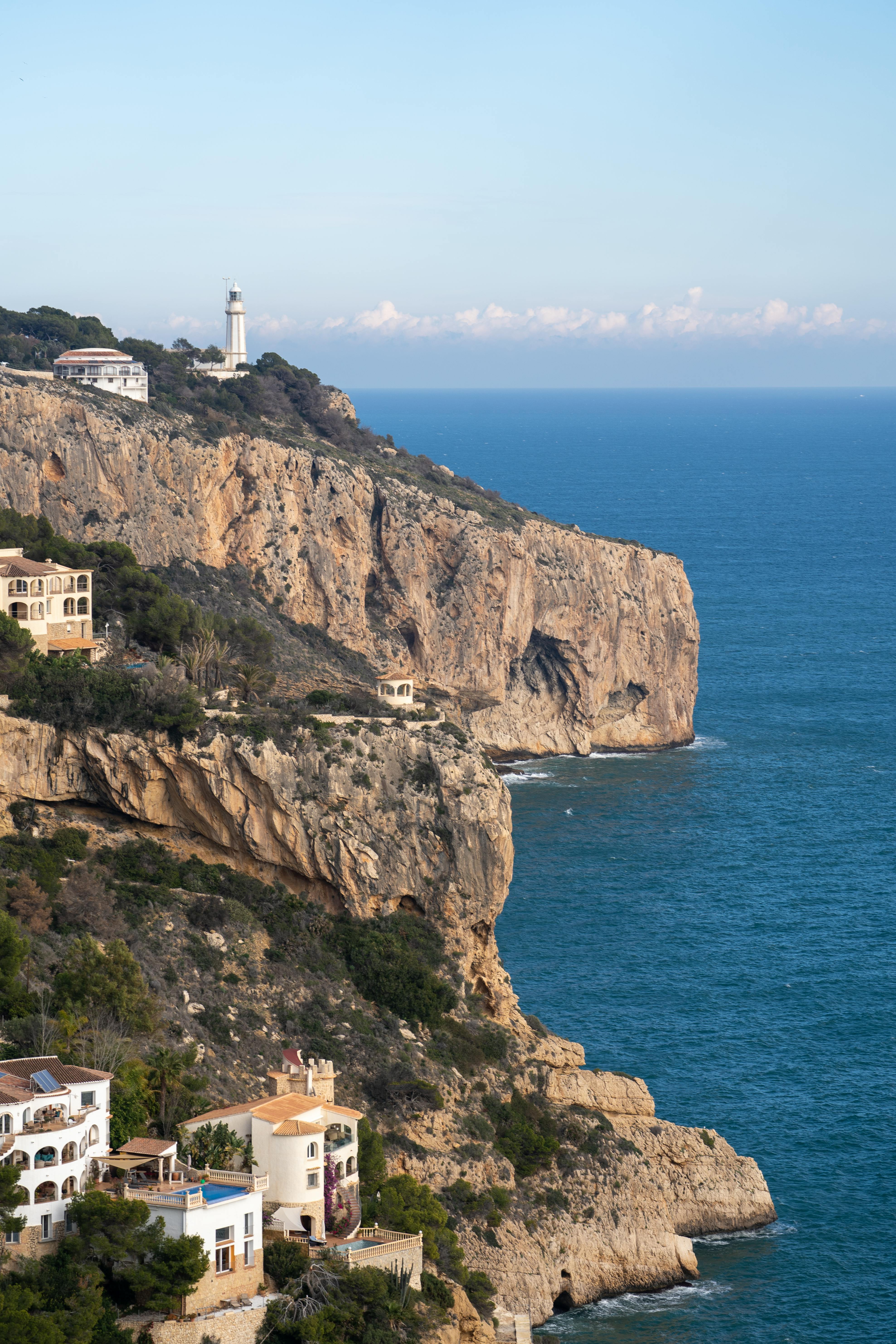 Cliffs of Cap de la Nau in Xàbia with the lighthouse in the background and the blue Mediterranean, one of the most spectacular viewpoints in Alicante